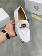 White slip-on loafer with gold buckle and stitched vamp detail
