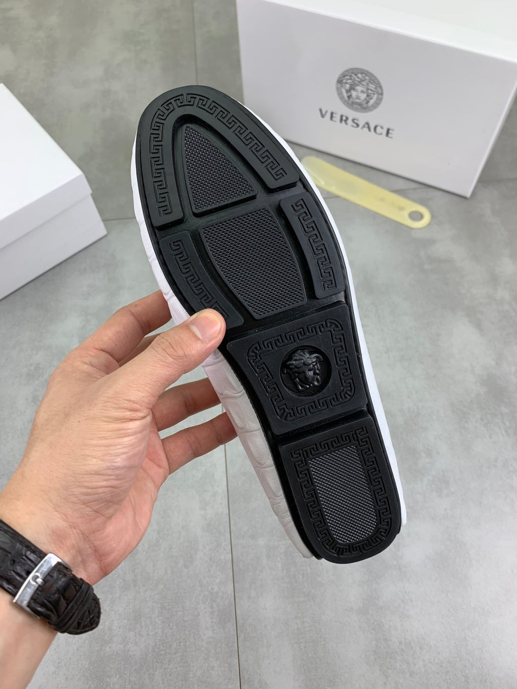 Black loafer outsole with textured tread pattern and embossed logo