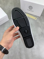 Black loafer outsole with textured tread pattern and embossed logo