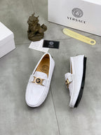 White slip-on loafers, one side view showing gold buckle and black sole edge