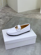 White slip-on loafer with gold buckle hardware on the front strap