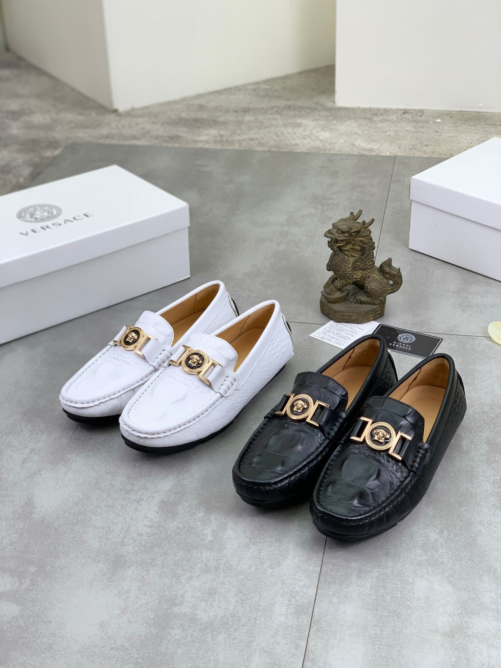 Set of white and black slip-on loafers with gold-tone buckle emblems