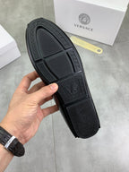 Black loafer outsole with textured grip pattern and logo lettering at heel