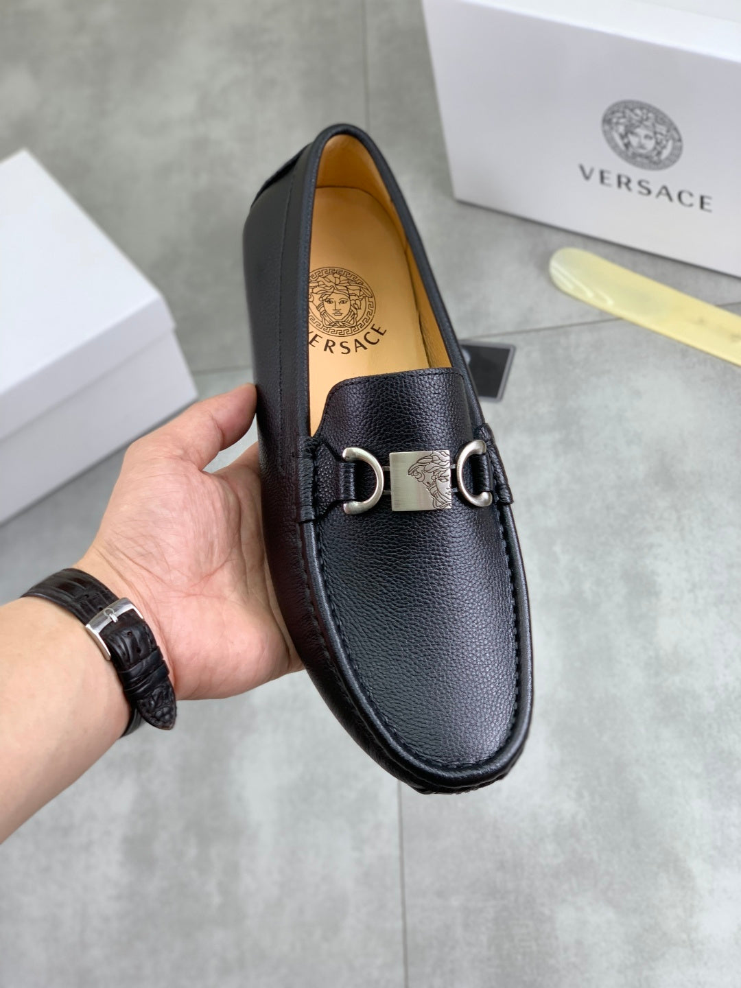 Black leather loafers with silver buckle and metal horsebit detail