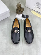 Black leather loafers, front view set of two with silver buckle detailing