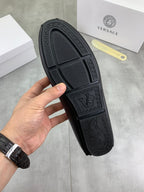 Black rubber outsole with textured designer logo pattern on loafer