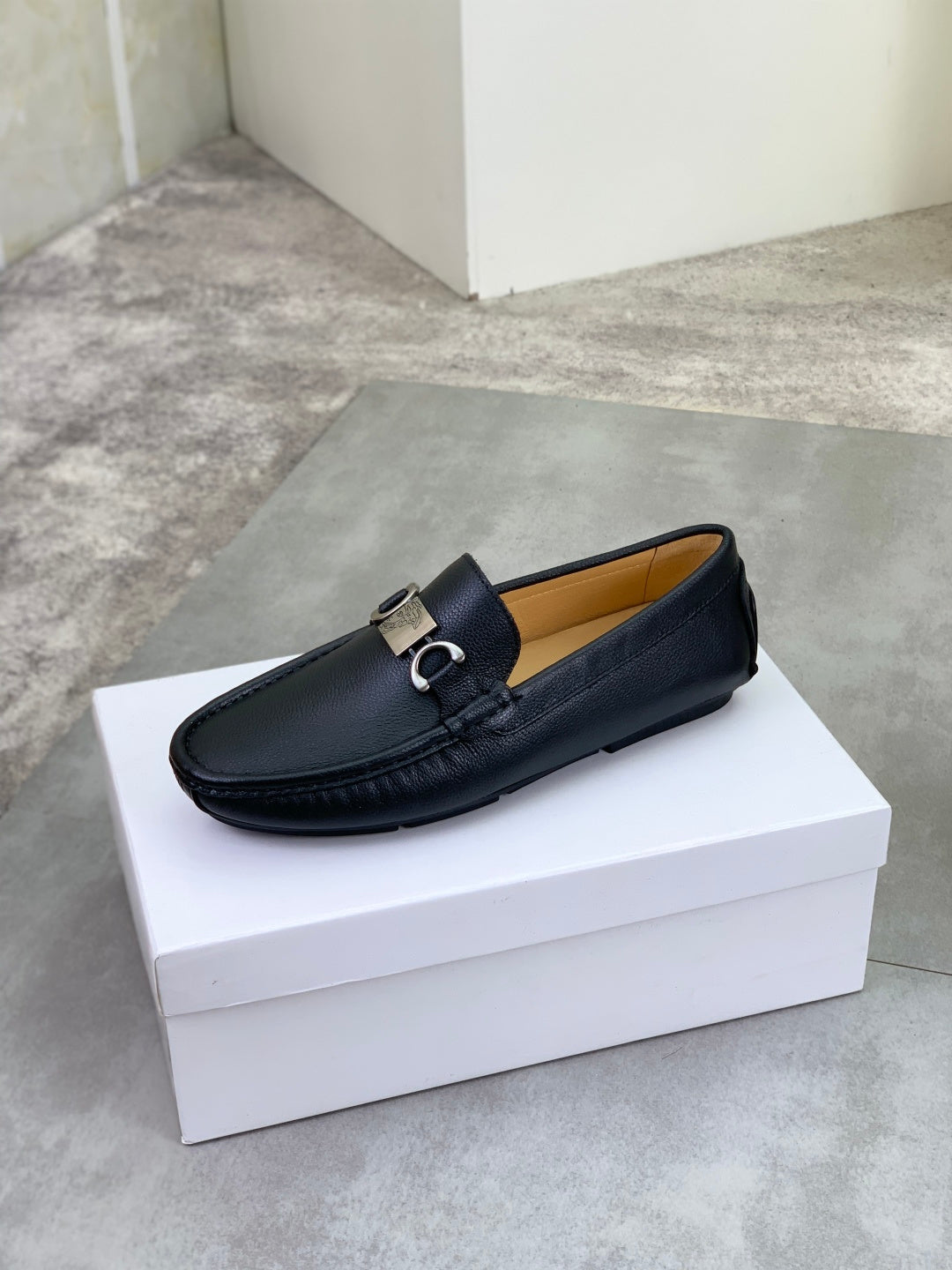 Black leather loafer with silver buckle, slip-on design