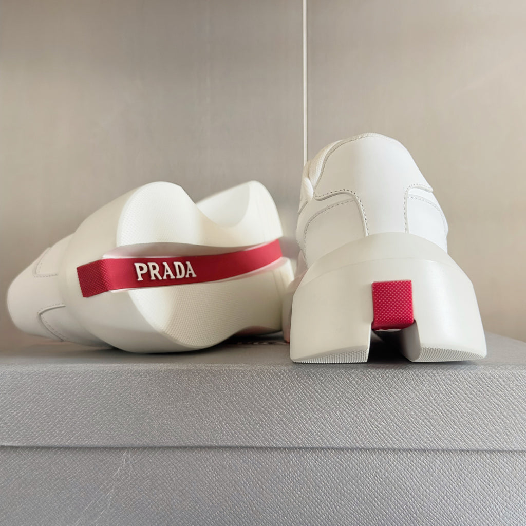 Prada unisex sneakers, heel view with red logo band and chunky white platform sole