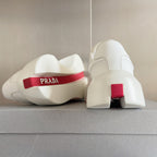Prada unisex sneakers, heel view with red logo band and chunky white platform sole