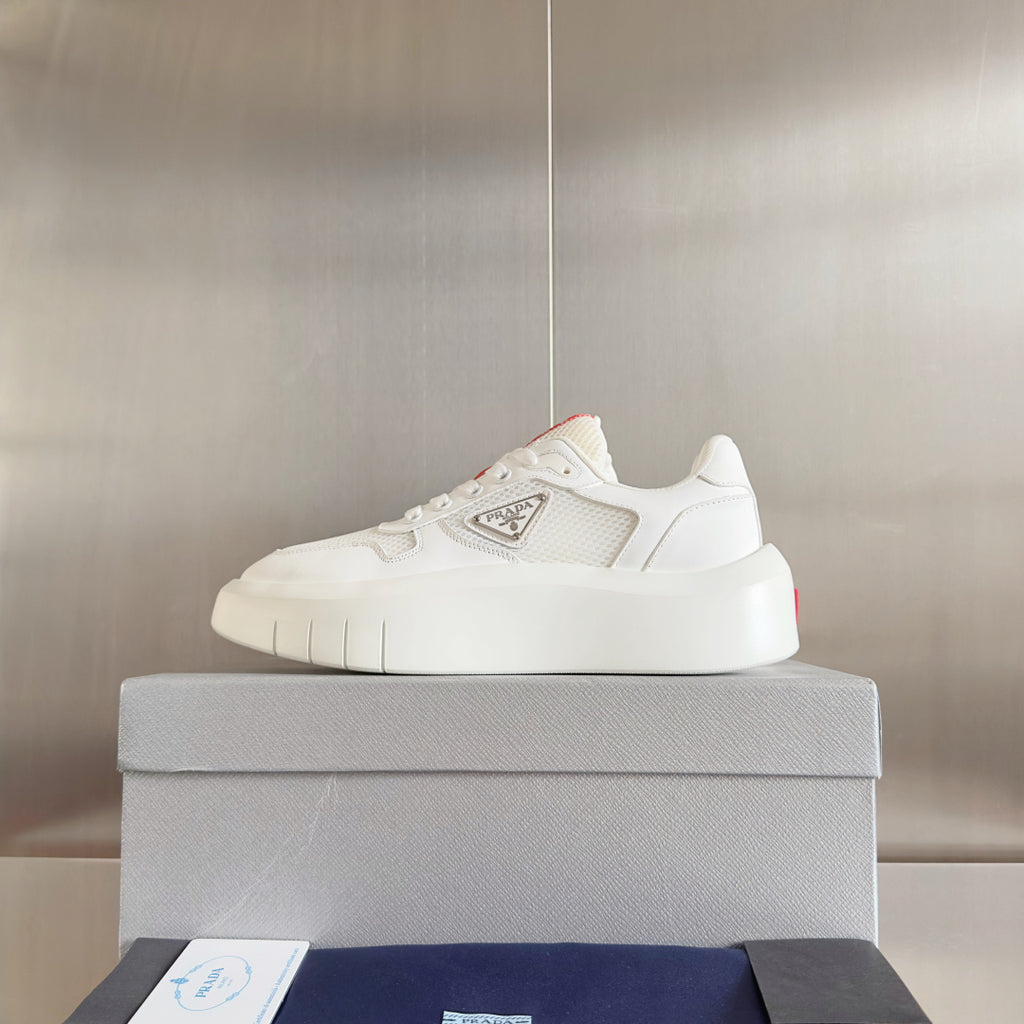 Prada unisex sneakers, front view on box; white platform sole and logo patch