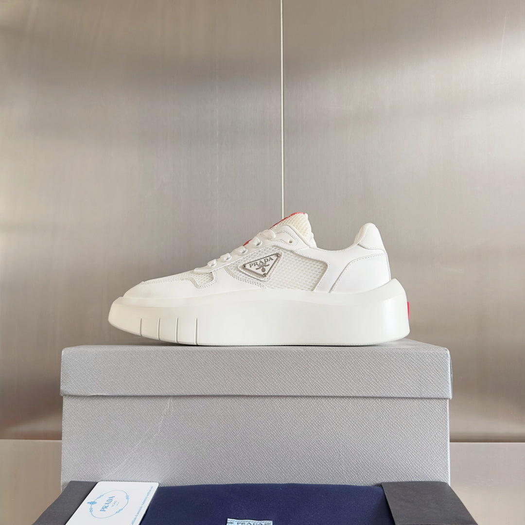 Prada unisex sneakers, front view on box; white platform sole and logo patch
