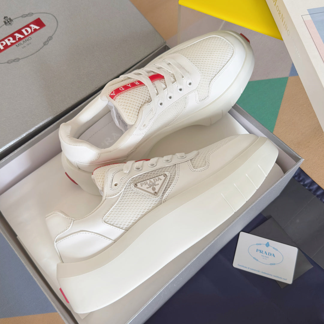 Prada unisex sneakers in box, white leather and mesh uppers with red heel accents