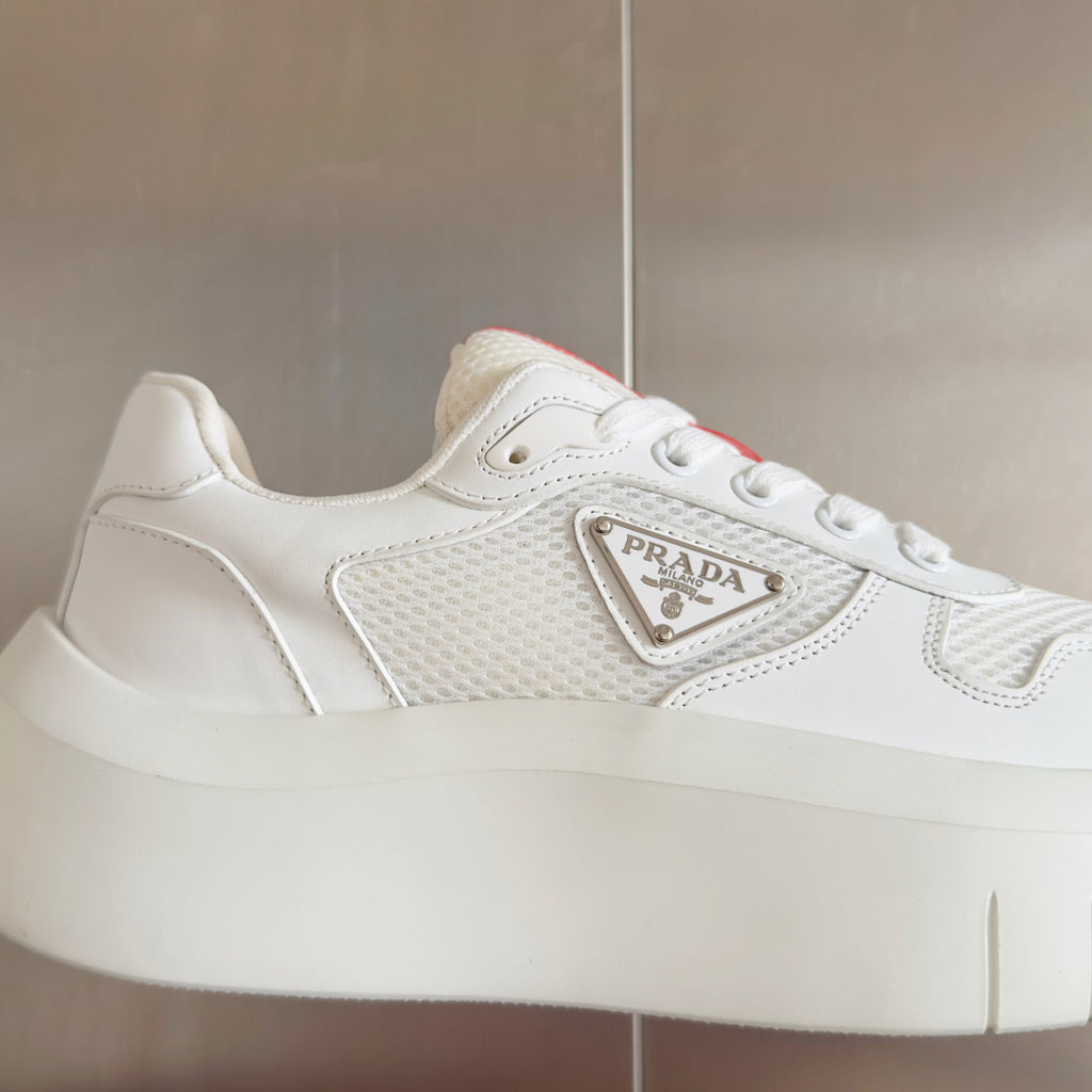 Prada unisex sneakers, close-up of side with Prada logo plaque and mesh texture