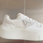 Prada unisex sneakers, close-up of side with Prada logo plaque and mesh texture