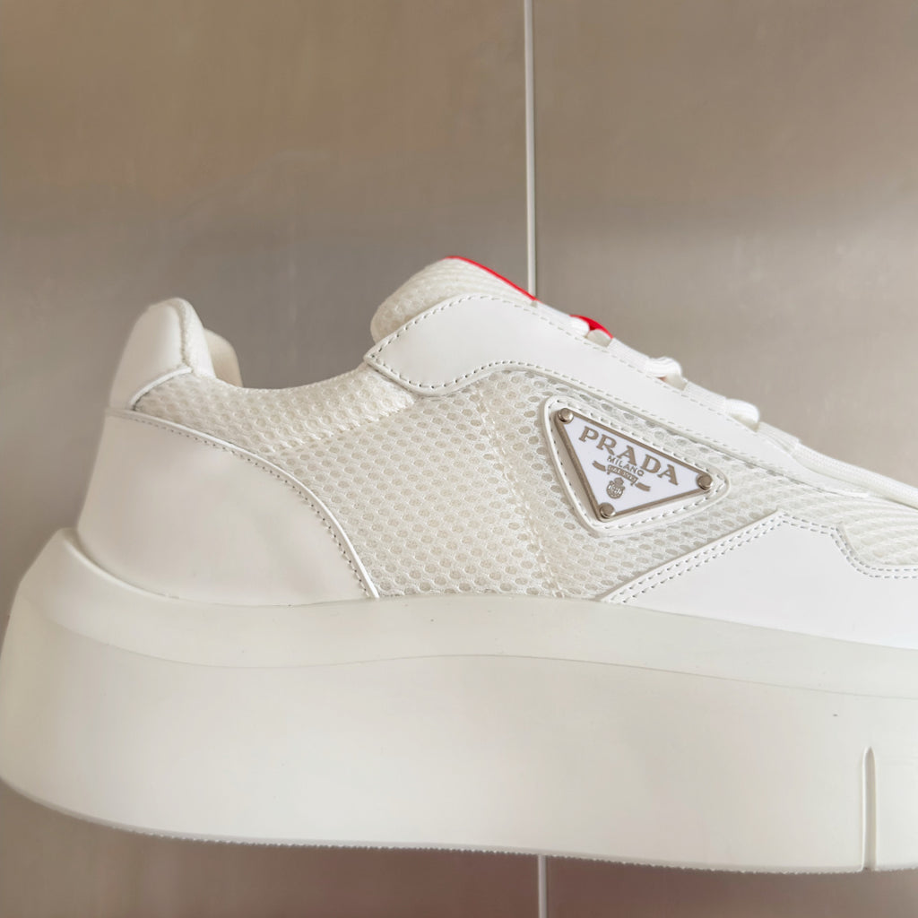 Prada white sneaker side close-up with logo plaque and lace-up trim