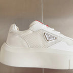Prada white sneaker side close-up with logo plaque and lace-up trim