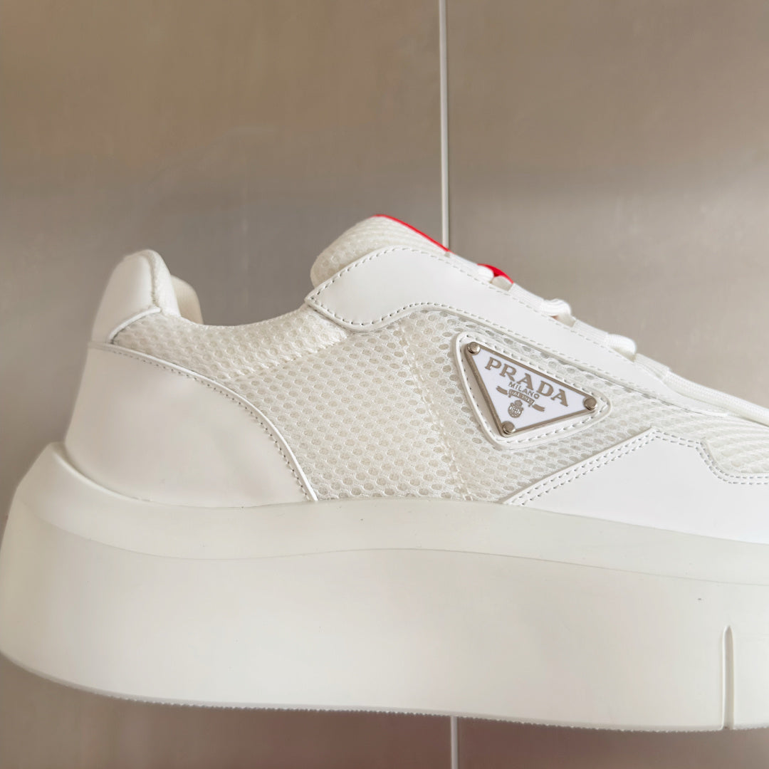 Prada white sneaker side close-up with logo plaque and lace-up trim