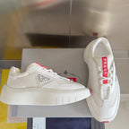 Prada white sneakers on display with thick white sole and red accent laces