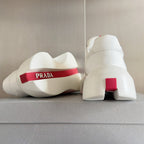 Prada white sneakers heel view with red logo tab and chunky sole