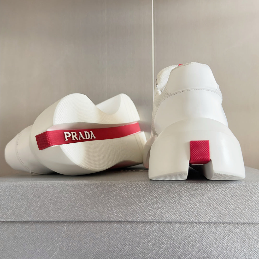 Prada white sneakers heel view with red logo tab and chunky sole