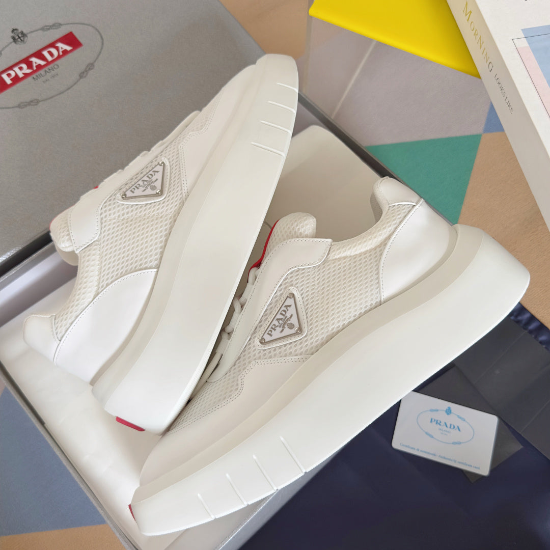 Prada white sneakers with mesh-textured uppers, side badge, and thick sole