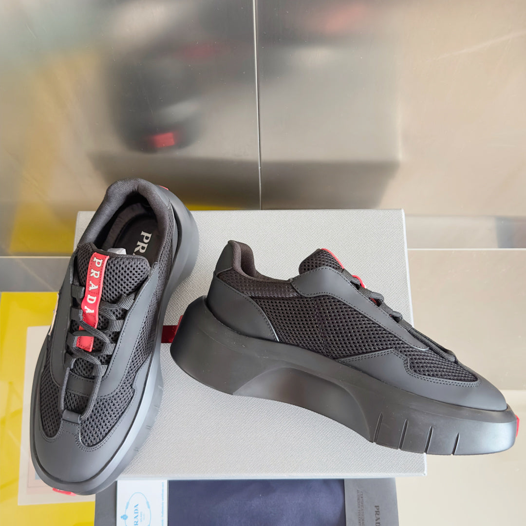 Prada unisex sneakers, dark gray knit-texture upper, chunky gray sole, red trim
