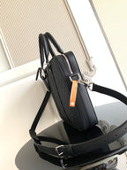 Dark woven handbag with dual handles, shoulder strap, and front zipper pocket