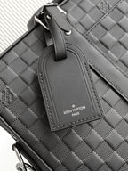 Dark woven handbag handle with logo tab and stitched trim detail