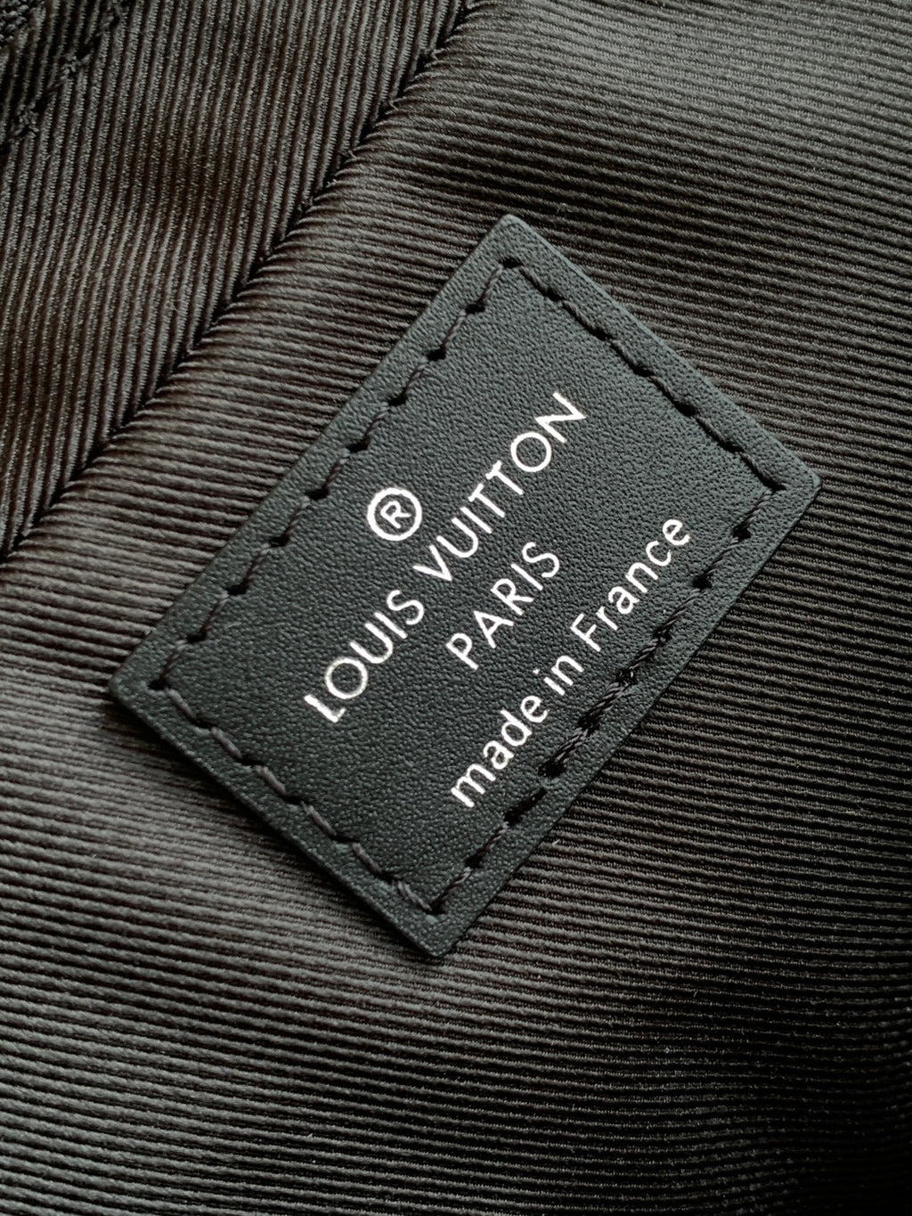 Louis Vuitton fabric label patch with 'made in France' text on dark lining