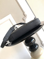 Dark shoulder handbag with strap and metal feet, side view