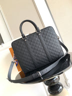 Dark woven tote-style handbag with top handles and adjustable shoulder strap