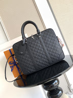 Louis Vuitton structured handbag in dark woven pattern with top handles and zip closure