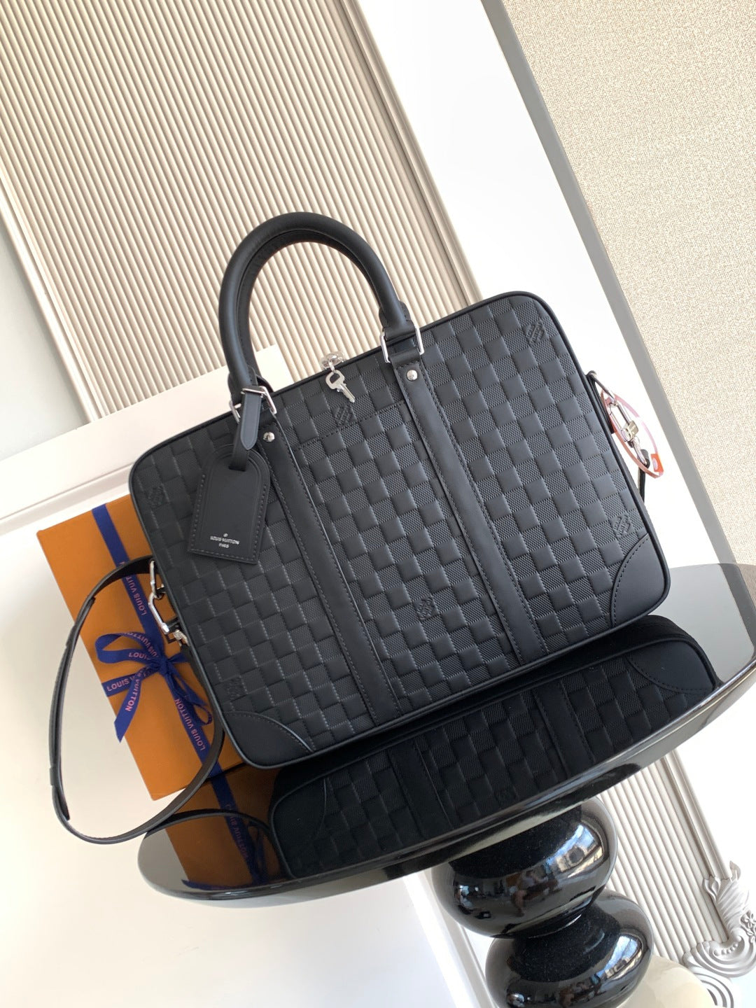 Louis Vuitton structured handbag in dark woven pattern with top handles and zip closure