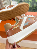 Louis Vuitton unisex sneakers close-up; brown upper with white side panel and outsole.
