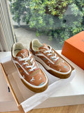 Louis Vuitton unisex sneakers, brown with white laces and stitched motif design.