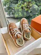 Louis Vuitton unisex sneakers, two brown pairs in boxes with white laces and motifs.