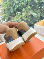 Louis Vuitton back view of blue plaid low-top sneakers with white laces and gum rubber soles.