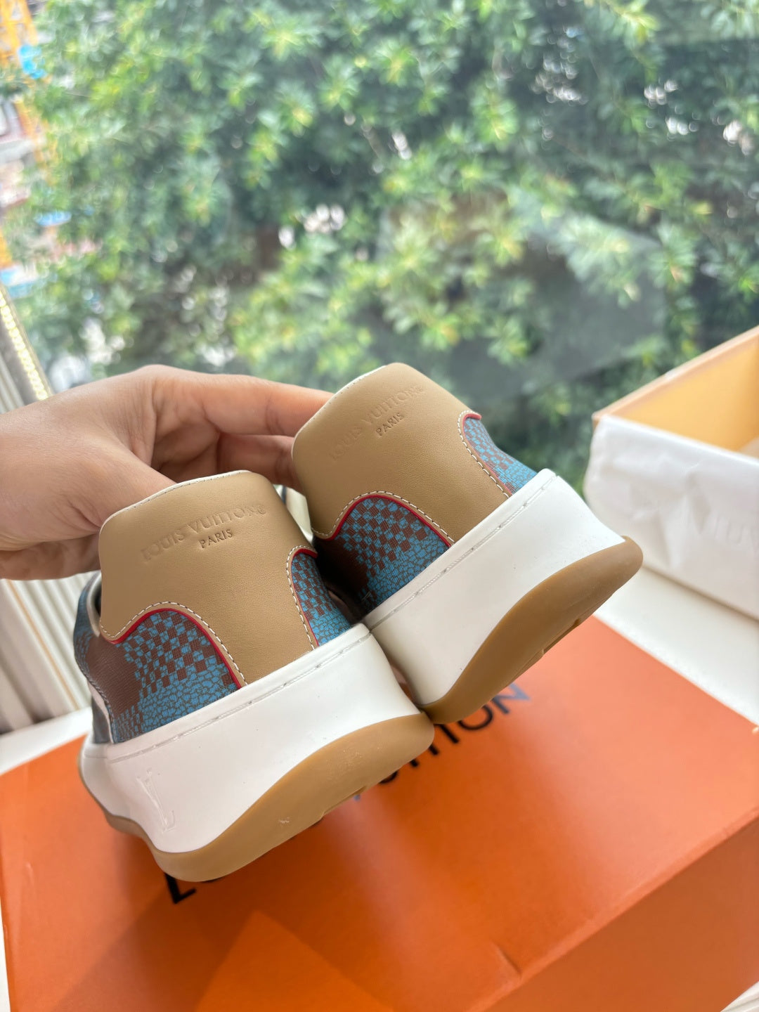Louis Vuitton back view of blue plaid low-top sneakers with white laces and gum rubber soles.