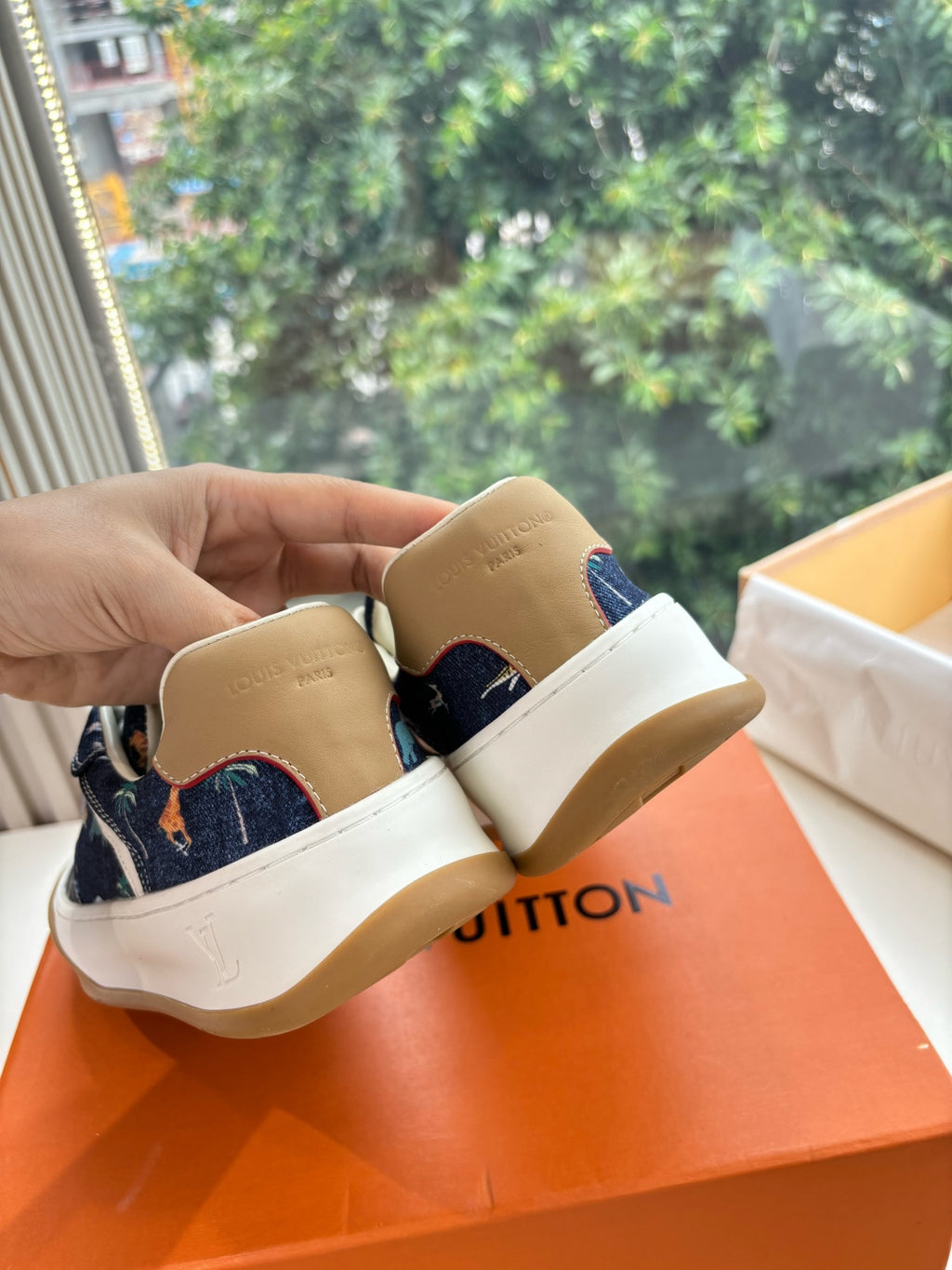 Heel and side view of low-top sneakers, dark blue canvas with tan rubber sole