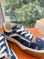 Close-up of low-top sneakers, dark blue canvas with white laces and tan sole