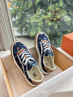 Low-top sneakers pair in dark blue with white laces and tan sole, side view