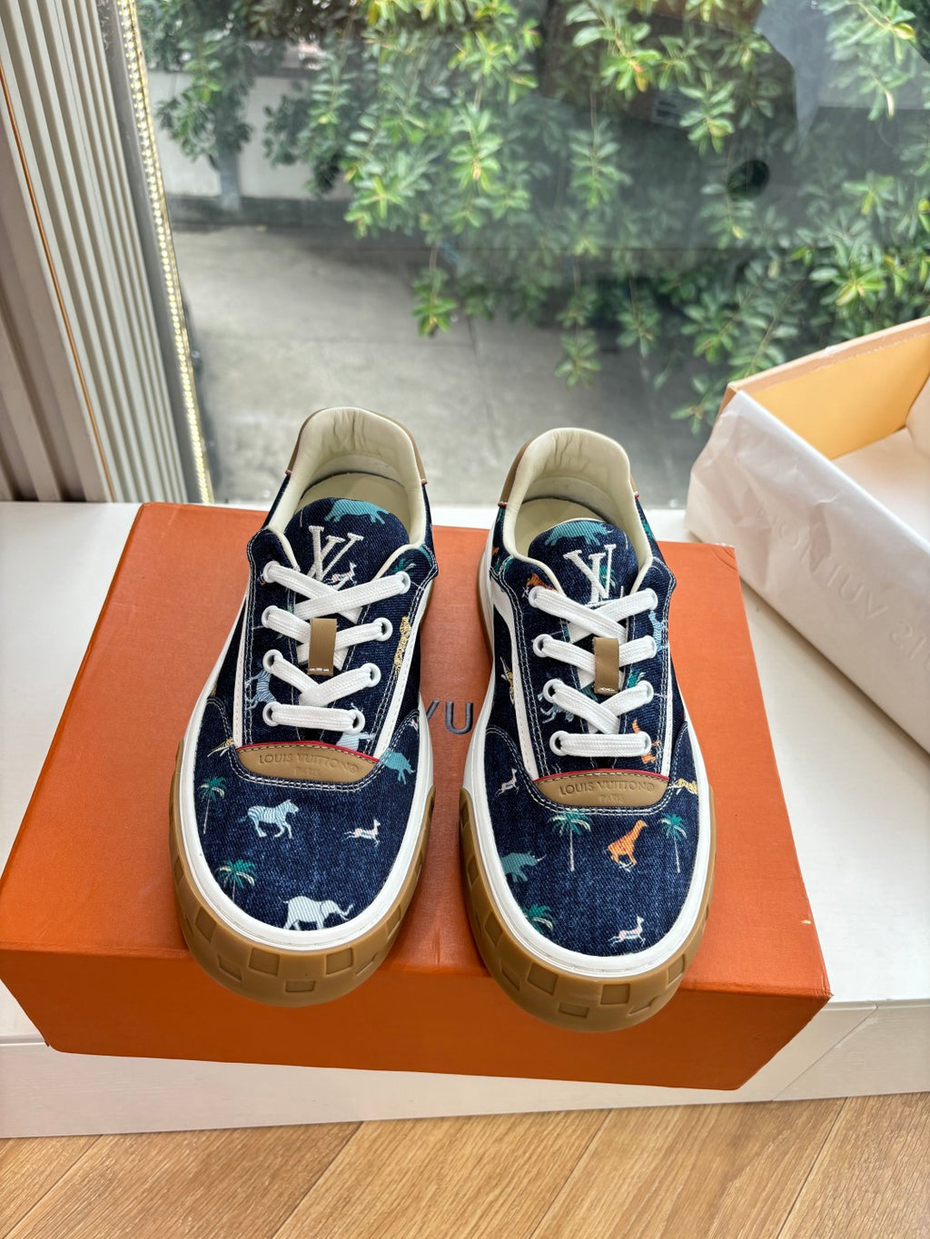 Low-top sneakers in dark blue canvas with white laces and tan sole, front view