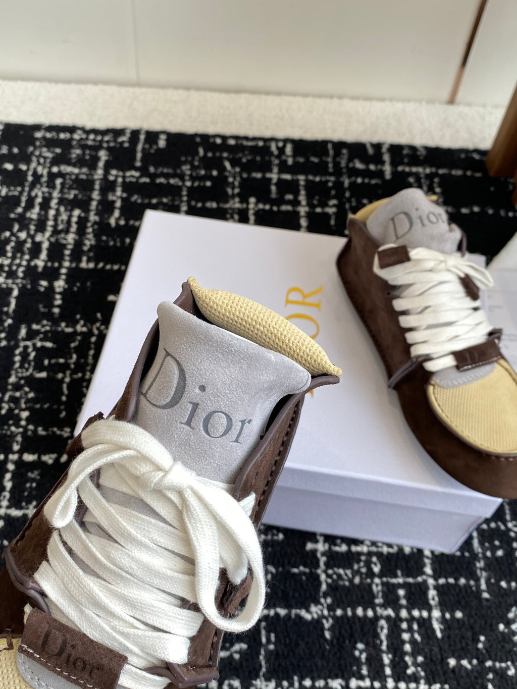 Dior unisex high-top sneakers close-up, brown suede with white laces and tan mesh