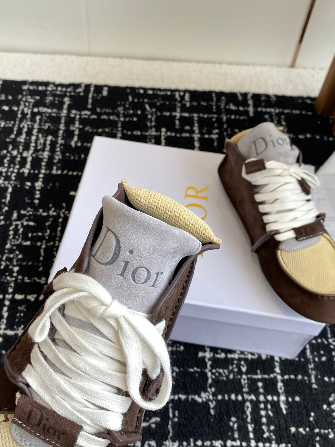 Dior unisex high-top sneakers close-up, brown suede with white laces and tan mesh