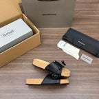 Black single slide sandal with front strap and silver buckle, cork footbed