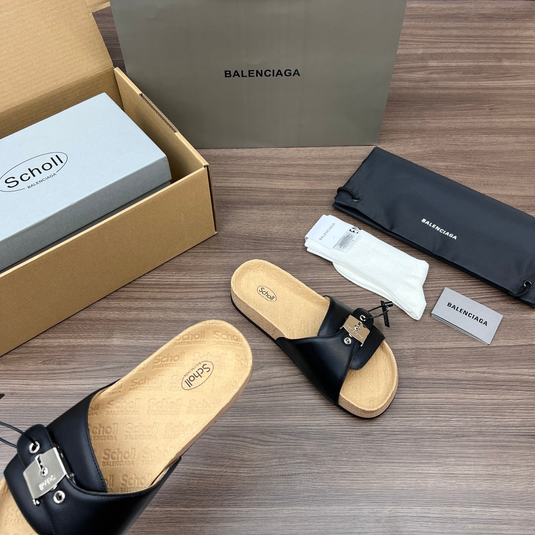 Black slide sandals with metal buckle strap and cushioned cork footbed