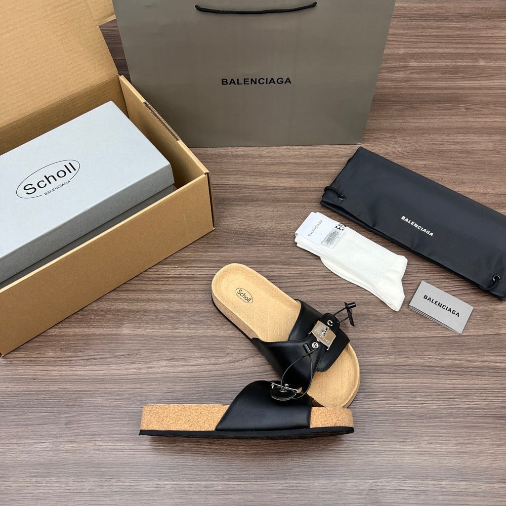 Black slide sandal with thick cork sole, front strap, and silver buckle detail