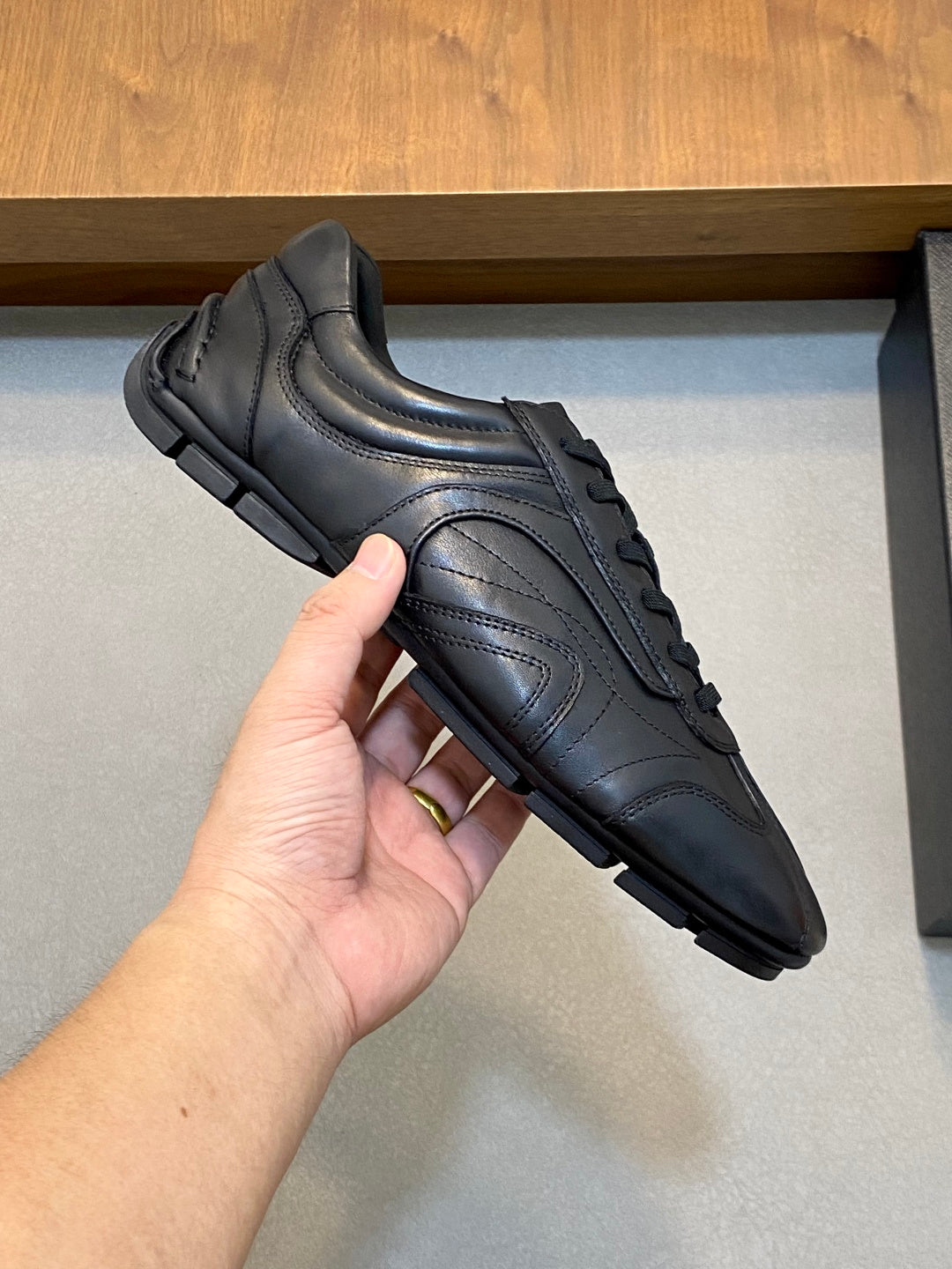 Black Prada unisex lace-up sneaker close-up, leather upper with stitched details
