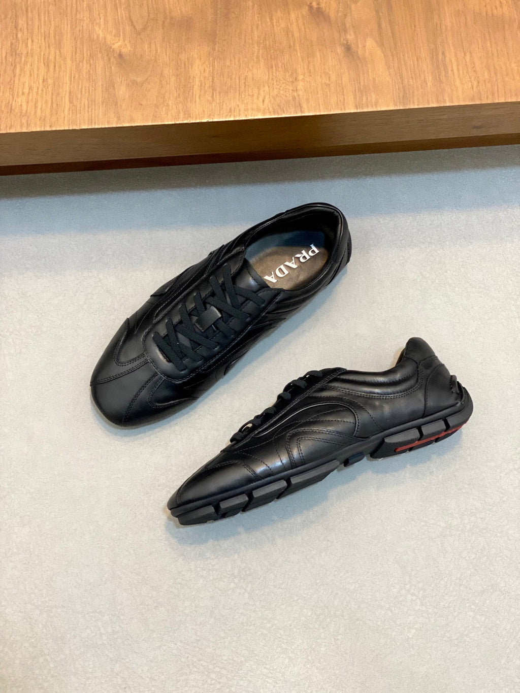 Black Prada unisex sneakers with lace-up tops, side and sole detail visible