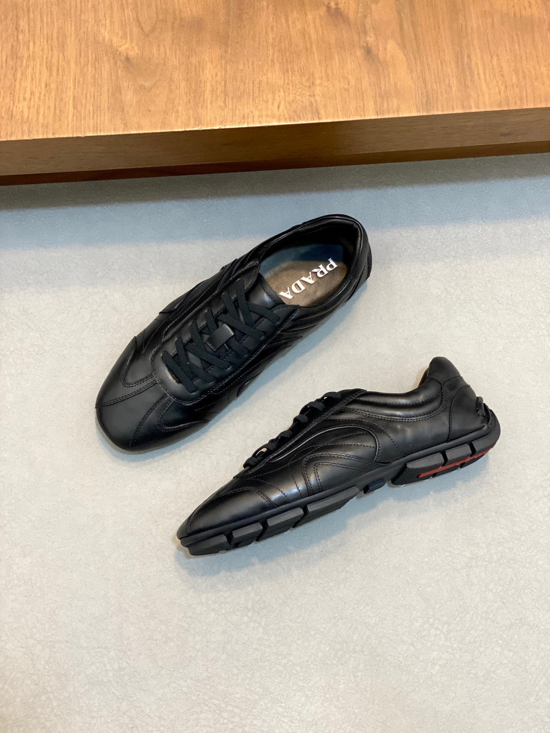 Black Prada unisex sneakers with lace-up tops, side and sole detail visible
